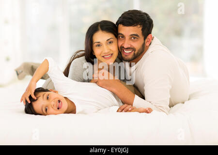 entzückende kleine Indianerjunge auf Bett liegend mit seinen Eltern Stockfoto