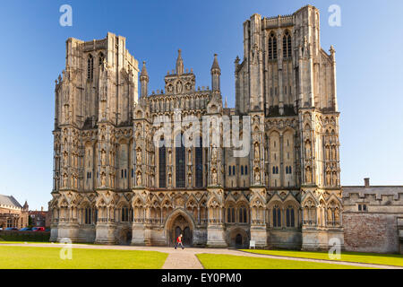 Ein Postbote Spaziergänge vor der prächtigen Westfassade der Kathedrale von Wells, Somerset, England, UK Stockfoto