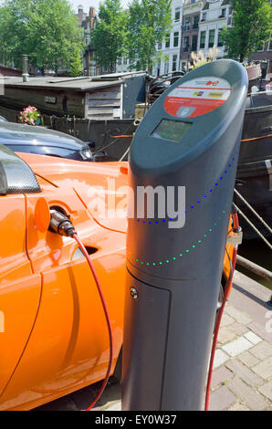 Orange Tesla Elektroauto aufladen Batterie am Straßenrand Amsterdam Holland Stockfoto