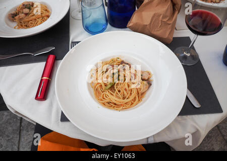 Zwei Schüsseln mit Spaghetti und ein Glas Rotwein. Stockfoto