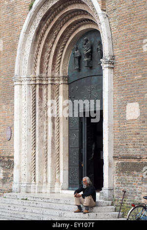 Ein Mann mittleren Alters sitzen auf den Stufen der Kathedrale von Cesena. Stockfoto