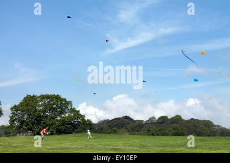 Tochter läuft in Richtung Vater im Feld mit Drachen fliegen, Margam Country Park, Port Talbot, South Wales. UK Stockfoto