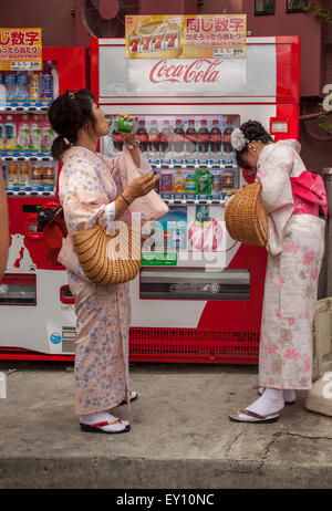 KYOTO, JAPAN - 29. Juni 2015: zwei weibliche Touristen in japanischen traditionellen Yukata Getränke aus dem Automaten kaufen Stockfoto