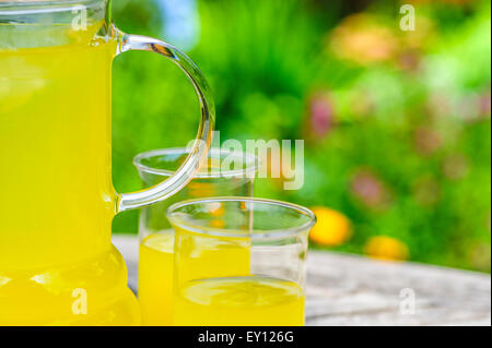 Krug mit gekühlten Orangensaft und zwei Gläser. Stockfoto