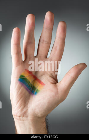 Die Hand des Mannes mit Regenbogen gemalt auf ihren Palm Stockfoto