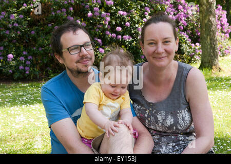Porträt von glücklichen Paar mit ihrem Baby Mädchen, in schönen Gärten Stockfoto