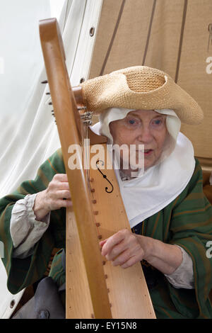 Eine Frau in traditioneller Kleidung spielen altmodische Harfe Stockfoto