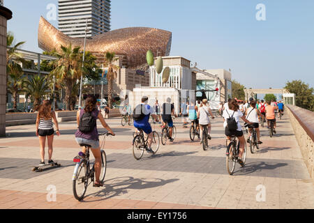 Radfahren entlang des Passeig Maritim Menschen, Skulptur Fische im Hintergrund, Barceloneta, Barcelona-Spanien-Europa Stockfoto