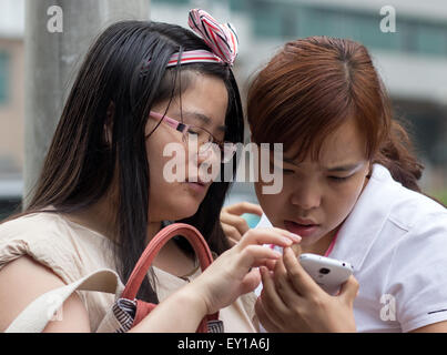 junge Frauen auf der Straße Shenzhen gerade zu mobile Stockfoto