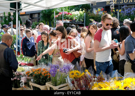 Menschen kaufen Blumen in Columbia Road market Stockfoto