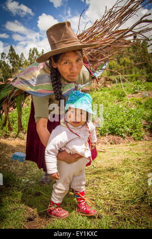 RAQCHI PERU-Januar 15: Unidentified Quechua indische Frau und Kind tragen Holz bei Raqchi Ruinen, Peru am 15. Januar 2013 Stockfoto