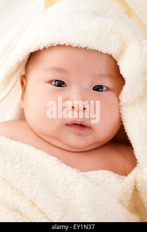 Baby Junge in eine Decke gewickelt und in die Kamera schaut, Stockfoto