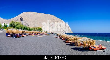 Santorin, Griechenland - 19. September 2010: Leute zum Sonnenbaden und Schwimmen am schwarzen Strand von Kamari in Santorin, Griechenland. Stockfoto