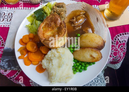 Traditionelles englisches Mittagessen Sonntag Schweinebraten und Füllung mit Yorkshire Pudding, Gemüse und ein Bier in einem pub Stockfoto