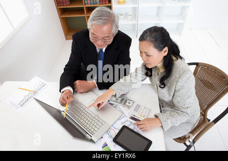 Älteres Paar, den Laptop zu betrachten und gemeinsam zu diskutieren, Stockfoto