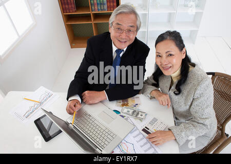 Älteres paar sitzen und Blick auf den Laptop zusammen, Stockfoto