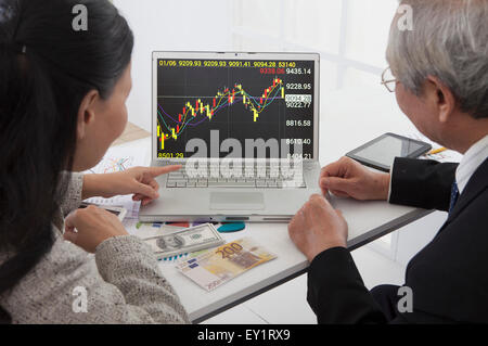 Älteres Paar sucht zum Marktpreis auf dem Laptop zusammen, Stockfoto