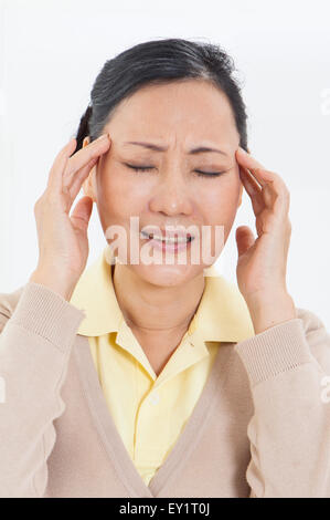 Ältere Frau, die Kopfschmerzen mit geschlossenen Augen, Stockfoto