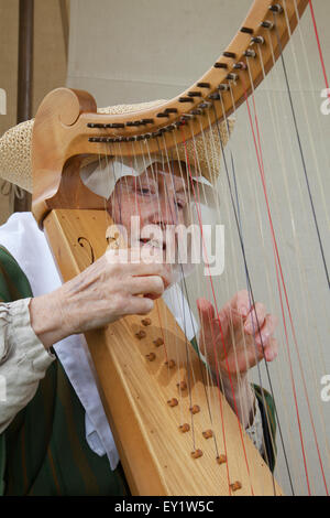 Eine Frau in traditioneller Kleidung spielen altmodische Harfe Stockfoto