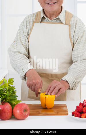 Senior woman Schneiden von Gemüse in der Küche, Stockfoto