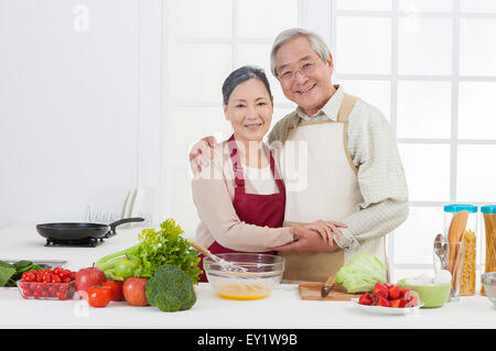 Älteres paar stehen in der Küche und glücklich lächelnd, Stockfoto