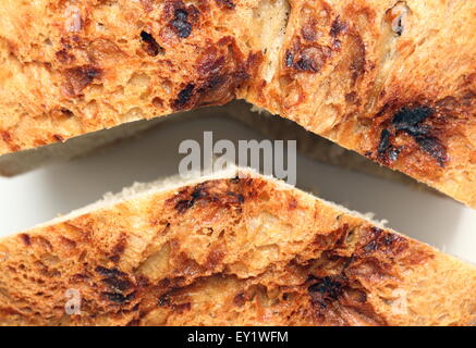 Detail der rumänischen selbstgebackenes Brot schneiden Sie in zwei Stücke auf einen weißen Tisch Stockfoto