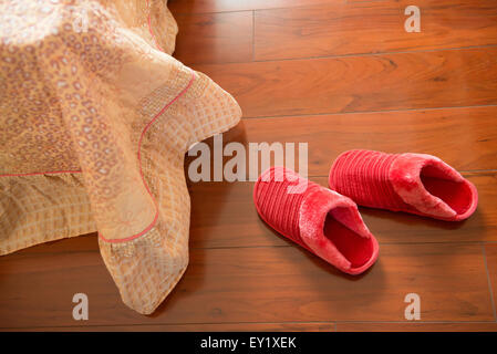 weiße Slipper Erdgeschoss in der Nähe ein Bett Stockfoto