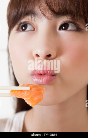 Junge Frau Sushi-Essen, Stockfoto