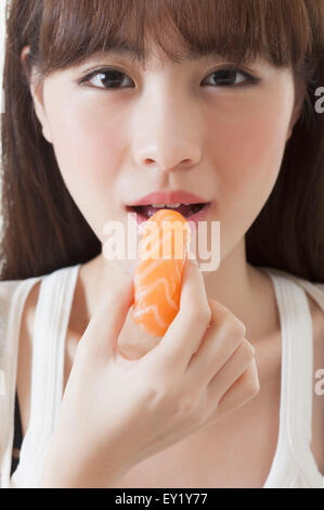 Junge Frau Sashimi Essen und lächelnd, Stockfoto