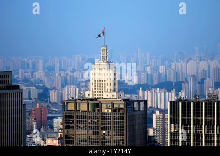 Hochhaus Edificio Banespa mit Flagge des Bundesstaates Sao Paulo gegen Stadtbild mit Wolkenkratzern, São Paulo, Brasilien Stockfoto