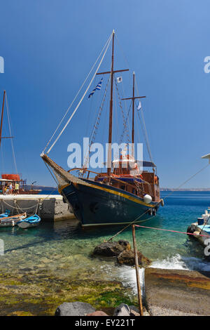 Boote vor Anker in dem kleinen Hafen auf der Insel Thirasia, Santorini, Griechenland. Stockfoto