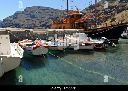 Boote vor Anker in dem kleinen Hafen auf der Insel Thirasia, Santorini, Griechenland. Stockfoto