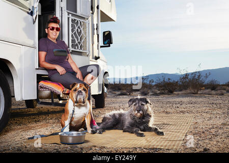 Porträt von Mitte Erwachsene Frau und seinen zwei Hunden sitzt auf Camper van Schritt, Borrego Springs, Kalifornien, USA Stockfoto