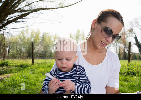 Baby Boy auf Mütter Schoß im Feld Stockfoto