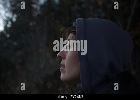 Porträt von Mitte Erwachsene Frau blicken Sie von Wald in der Dämmerung hautnah