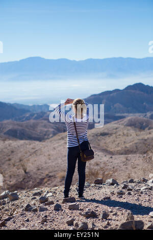 Junge Frau stehen auf Felsen, mit Blick auf Berge, Rückansicht Stockfoto