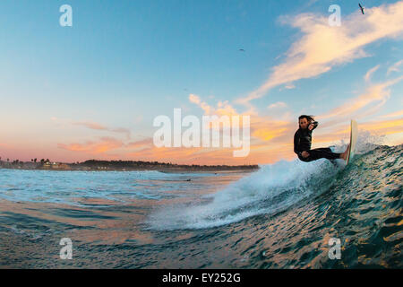 Junge männliche Surfer Surfen von einer Welle, Cardiff-by-the-Sea, Kalifornien, USA Stockfoto