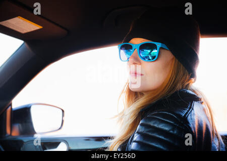Porträt von Mitte Erwachsene Frau auf Auto Roadtrip mit blauen Sonnenbrille Stockfoto