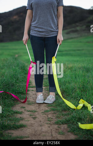 Schuss der jungen Frau im Feld halten Tanz Bänder abgeschnitten Stockfoto