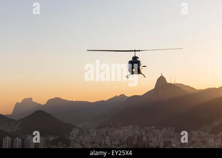 Silhouette Ansicht des Hubschraubers und der Christusstatue in der Morgendämmerung, Rio De Janeiro, Brasilien Stockfoto