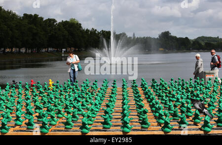 Schwerin, Deutschland. 20. Juli 2015. Passanten schauen Sie sich die Installation "Einheitsmaennchen" (wörtl. Einheit Männlein) durch Konzeptkünstlers Ottmar Hoerl in Schwerin, Deutschland, 20. Juli 2015. Mehr als 1.000 Plastikfiguren, die von der ehemaligen DDR "Ampelmaennchen" (wörtl. Ampel Männchen) inspiriert worden sein, wird ein Teil der bundesweiten Feierlichkeiten anlässlich des 25. Jahrestages der deutschen Wiedervereinigung sein. Foto: Bernd Wuestneck/Dpa/Alamy Live News Stockfoto