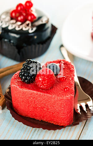 Rosa Kuchen mit Beeren auf hölzernen Hintergrund Stockfoto