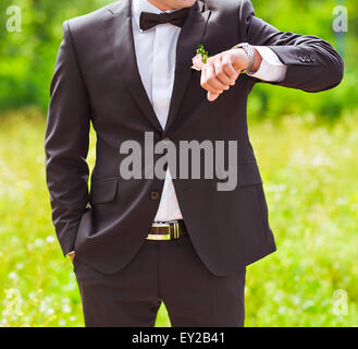 junger Geschäftsmann Blick von Watch auf weißem Hintergrund Stockfoto