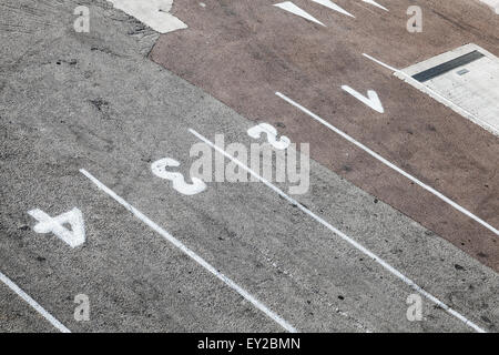 Fähren-terminal Hafen Ladefläche, Straße Kennzeichnung mit Spur Nummerierungen und Trennlinien auf grauen asphalt Stockfoto