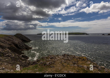 Küste von Süd-Wales mit schweren Wolken und blauer Himmel mit einem felsigen Halbinsel. Stockfoto