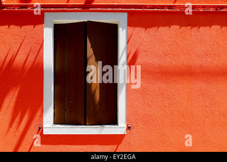 Fenster-Haus in Burano auf orange Farbe Wand Gebäudearchitektur, Venedig, Italien Stockfoto