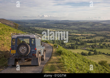 Land Rover Defender auf einer schmalen Panoramastraße absteigend aus Long Mynd Ridge, Shropshire, England, UK Stockfoto