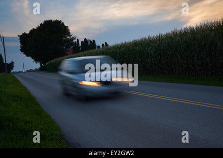 Auto beschleunigt nach unten einen Feldweg an der Dämmerung, Lancaster County Pennsylvania, USA Stockfoto