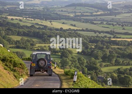 Land Rover Defender auf einer schmalen Panoramastraße absteigend aus Long Mynd Ridge, Shropshire, England, UK Stockfoto