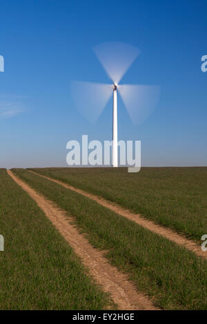 Spinnerei Schaufeln Windturbine im Feld gegen blauen Himmel Stockfoto